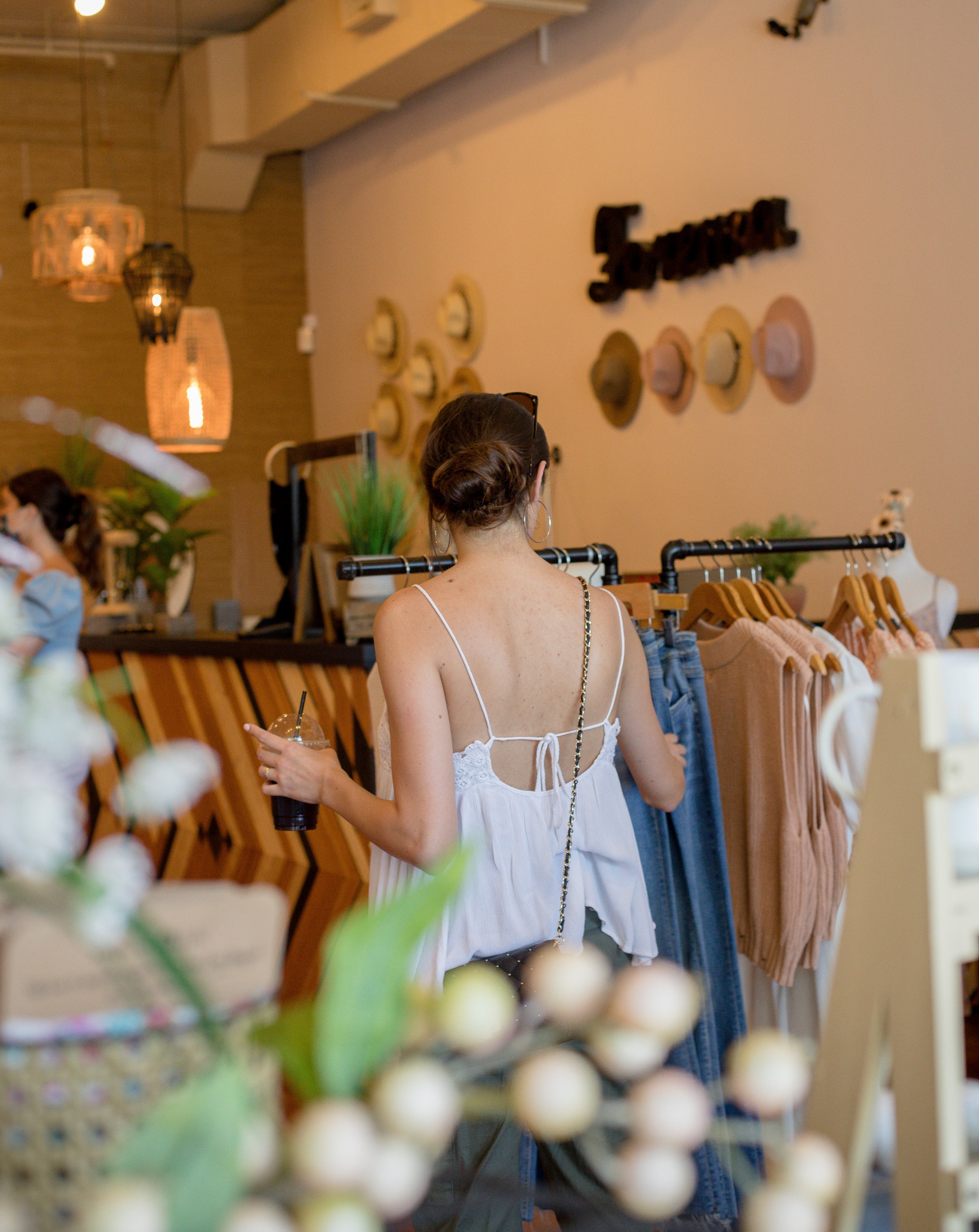 person-browses-clothing-racks-in-a-store - OneCatBoutique